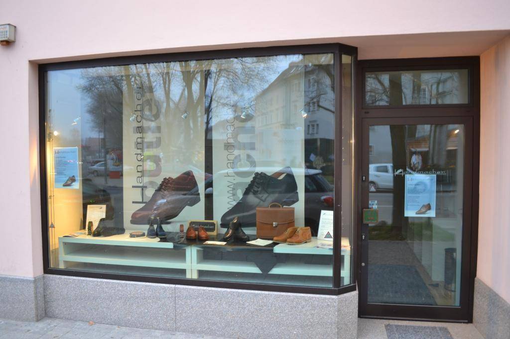 Detaillierte Ansicht des Schaufensters eines Schuhgeschäfts mit verschiedenen Ausstellungsstücken.
