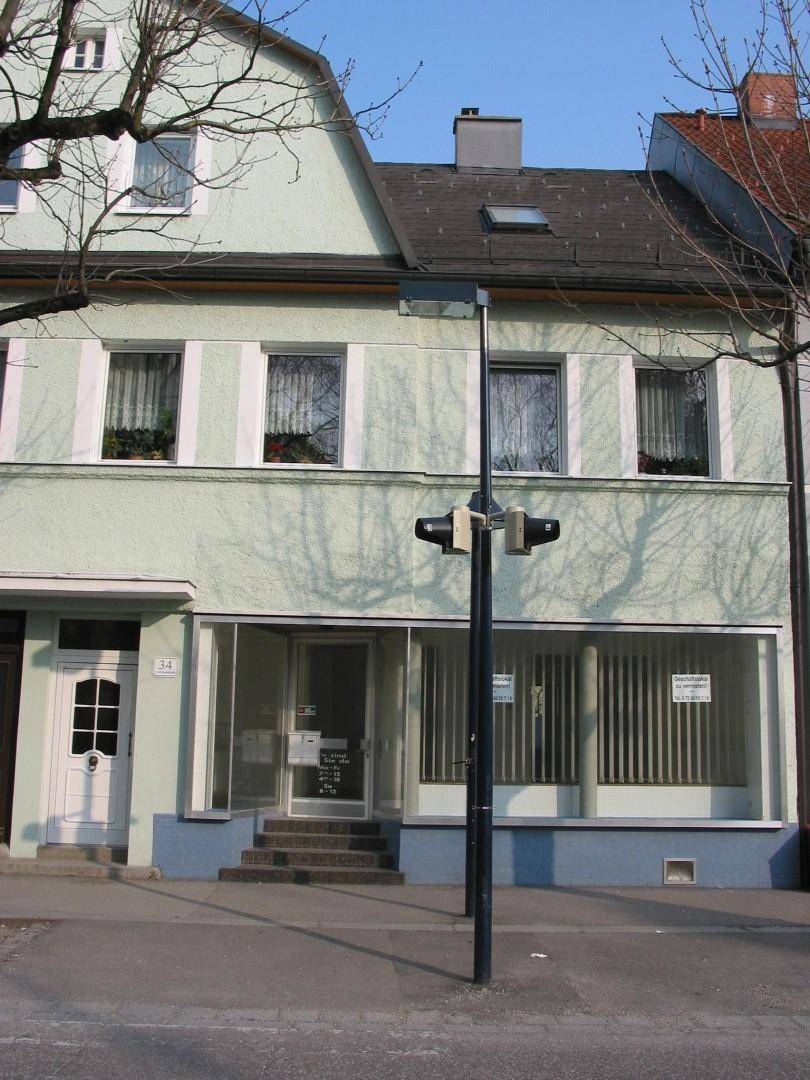 Gesamtansicht der Geschäftsfassade mit Wohnungen im Obergeschoss und einem Dachfenster.
