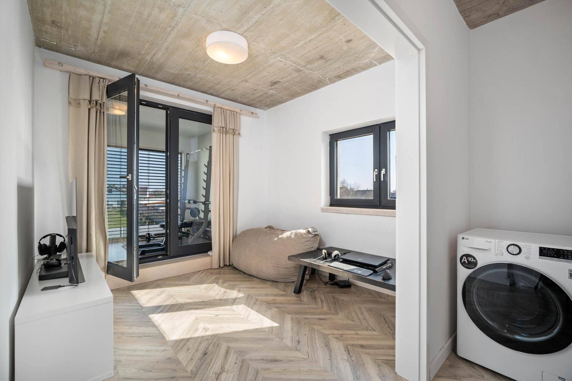 Mehrzweckraum mit Waschmaschine, Fenster und Zugang zu einem französischen Balkon.