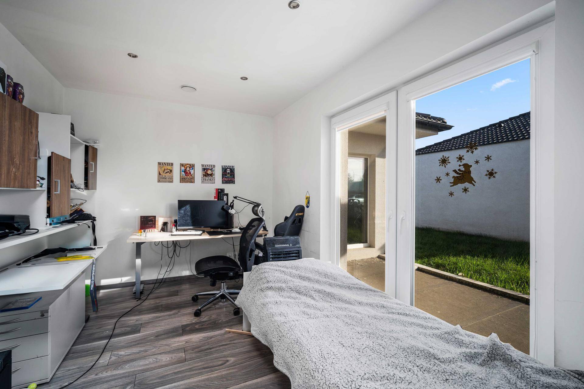 Geräumiges Zimmer mit Schiebetür zum Außenbereich und Arbeitsplatz.