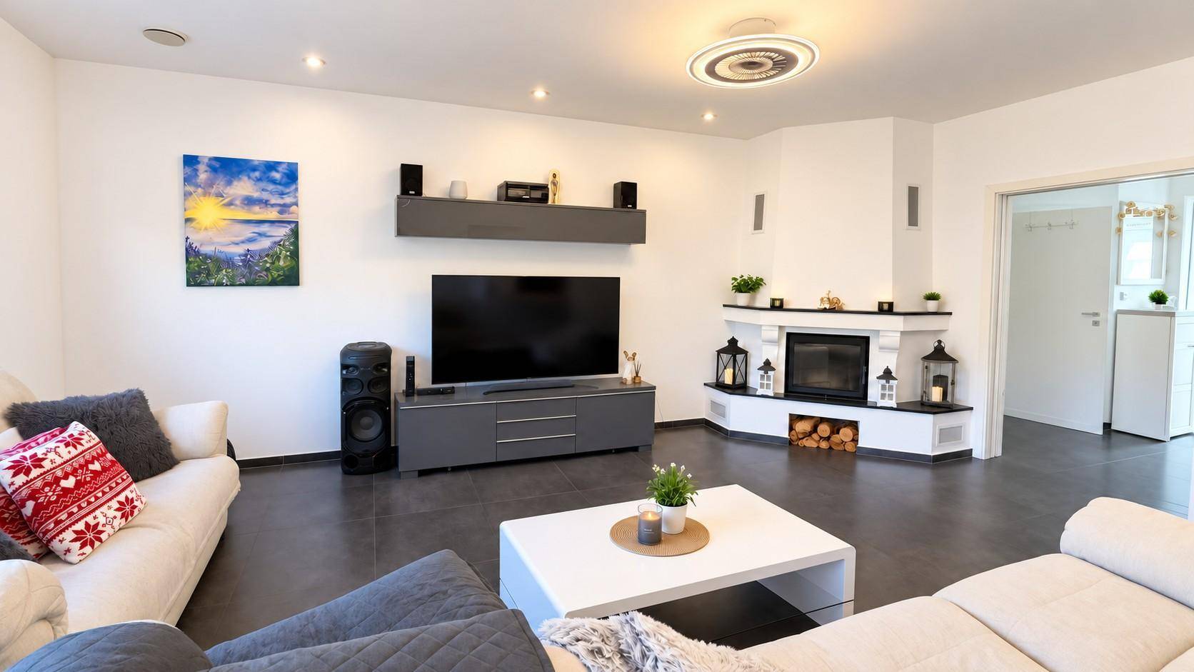 Modernes Wohnzimmer mit Kamin, dunklem Fliesenboden und bequemen Sofas.