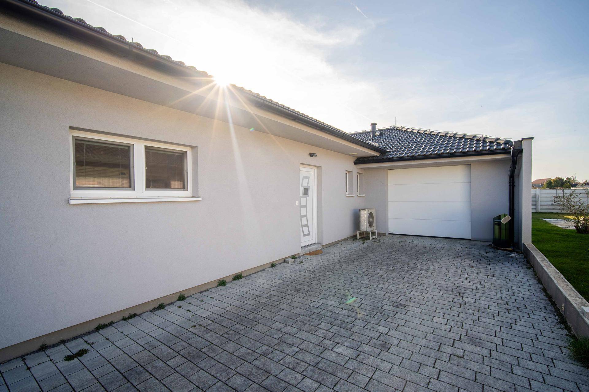 Hauszufahrt mit Garage, Stellplatz und moderner Fassade.