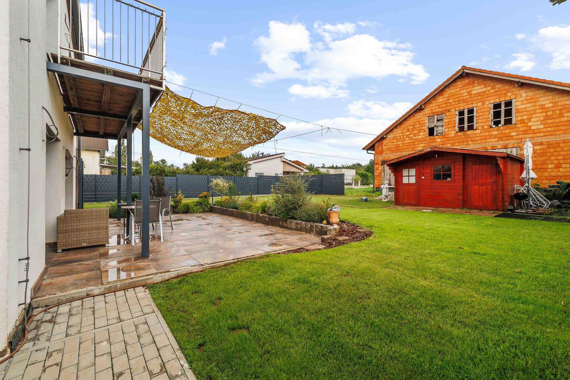 Gemütliche Terrasse mit Sitzgelegenheiten und Blick auf den gepflegten Gartenbereich.