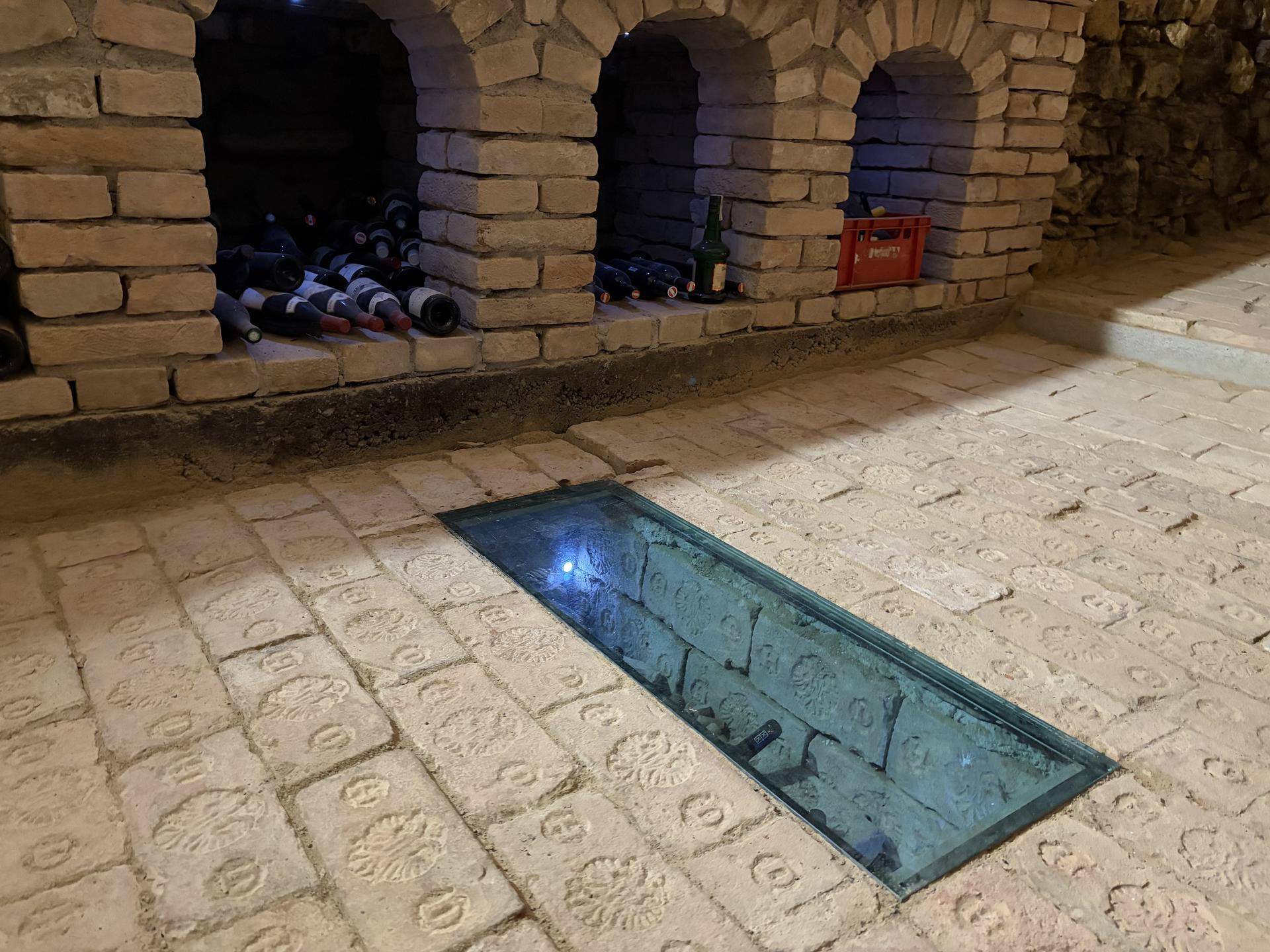 Detailansicht der gemauerten Weinregale und des Glasbodens im historischen Weinkeller.