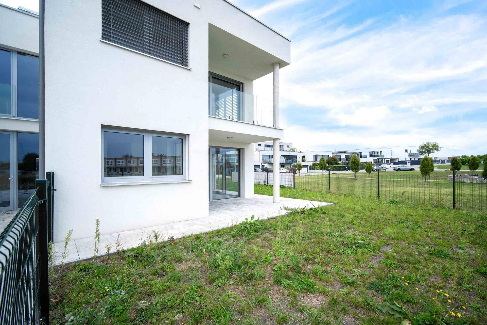 Gartenbereich mit kleiner Terrasse und Zugang zu einem weiteren Gebäude.