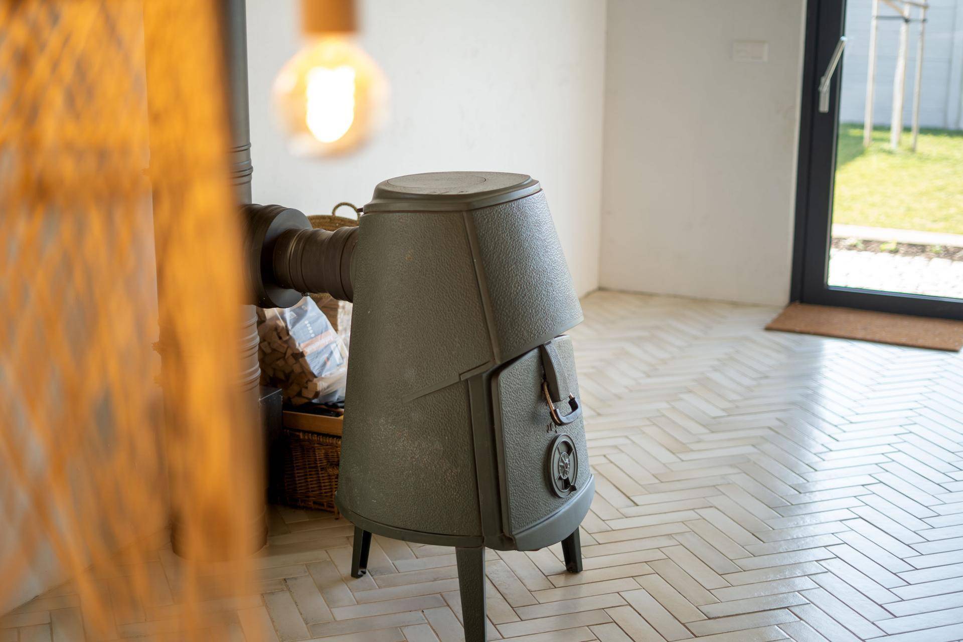 Kaminofen im Wohnzimmer mit Holzscheiten und Zugang zum Garten.