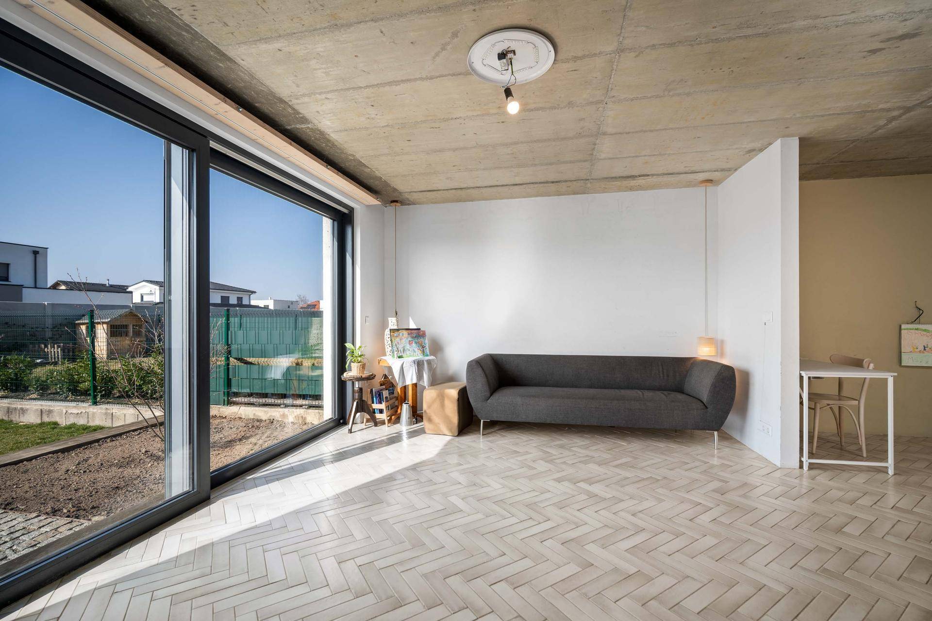 Lichtdurchfluteter Wohnbereich mit großen Fenstern, Gartenblick und moderner Einrichtung.