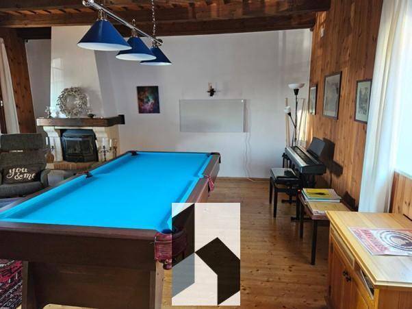 Freizeitraum mit Billardtisch, Klavier und einem gemütlichen Kamin für Unterhaltung.