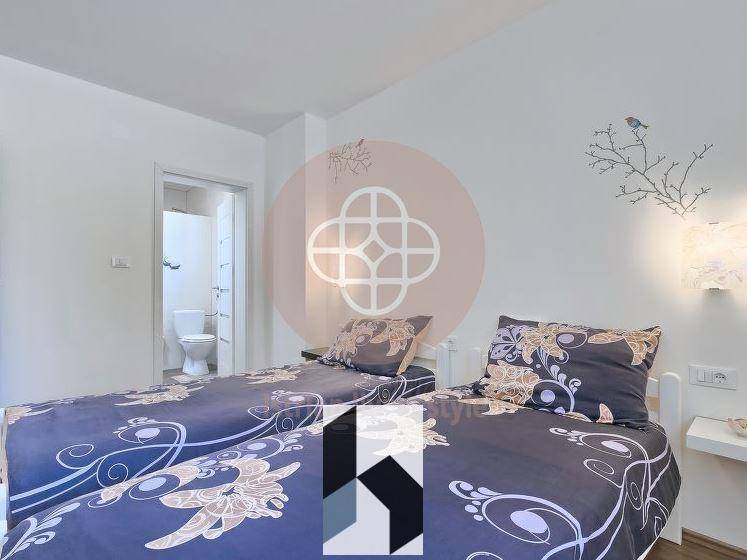 Schlafzimmer mit zwei Einzelbetten und Zugang zu einem angrenzenden Badezimmer.