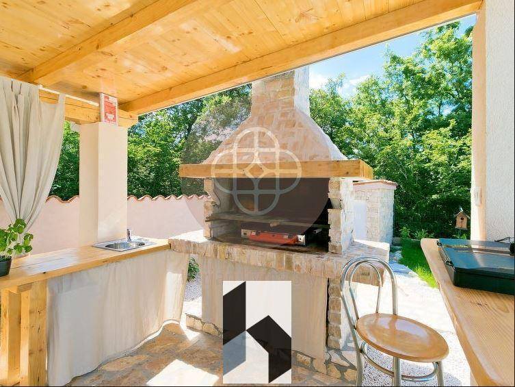 Große überdachte Terrasse mit Essbereich und Blick auf den Pool und den Garten.