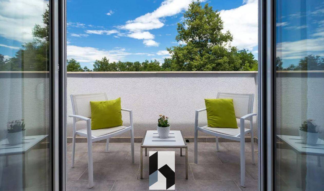 Kleiner, möblierter Balkon mit zwei Stühlen und einem Tisch, ideal zum Entspannen.