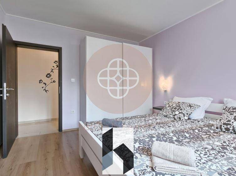 Schlafzimmer mit Doppelbett, Holzboden und großem Kleiderschrank in Pastellfarben.