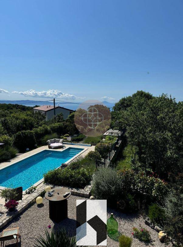 Großer Garten mit Pool, Meerblick und üppiger Vegetation.