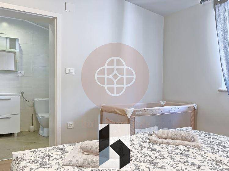 Schlafzimmer mit Doppelbett und Babybett, mit direktem Zugang zum Badezimmer.