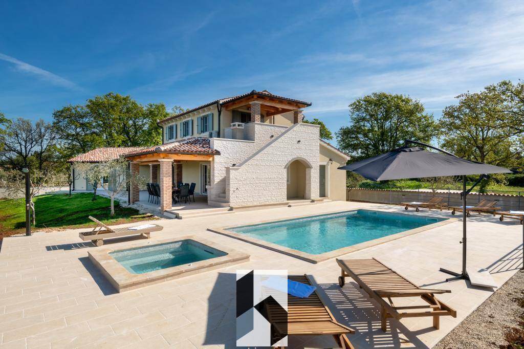 Sonnige Außenansicht der Villa mit großem Pool, Whirlpool und Liegebereich.