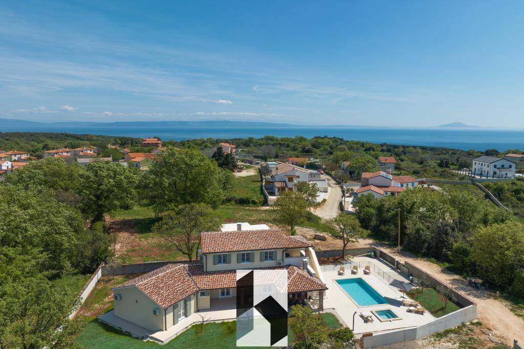 Luftaufnahme der Villa mit Poolbereich und weitem Blick auf das Meer und die Umgebung.