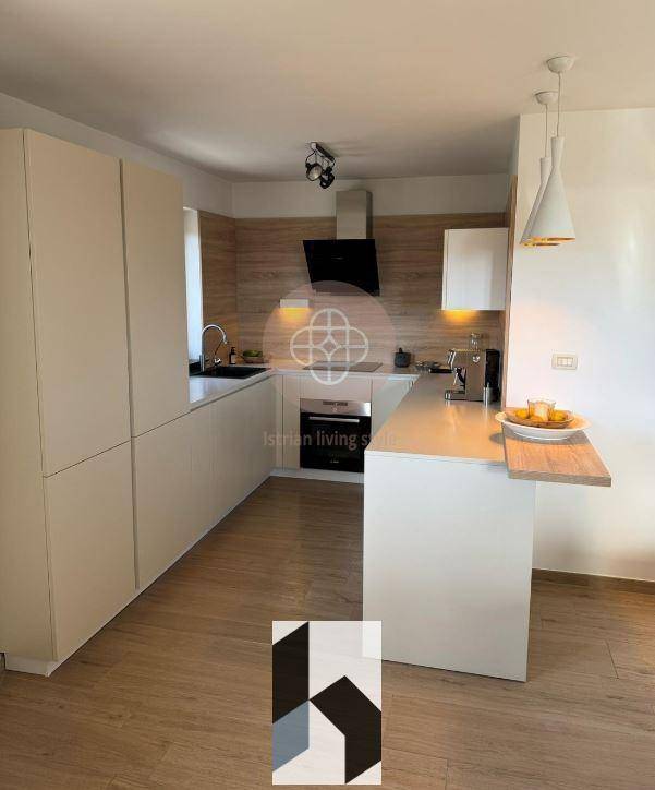 Moderne Küche mit hellen Schränken, Holzakzenten und integrierten Geräten.