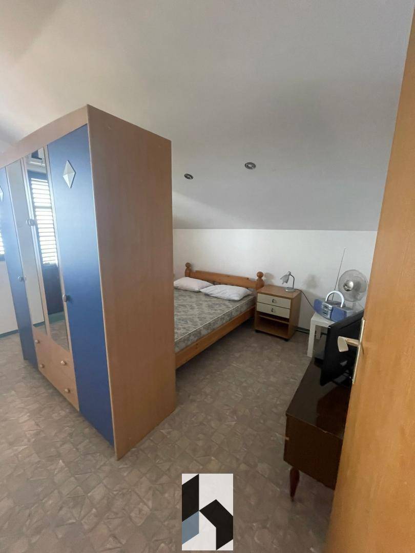 Schlafzimmer mit Bett, Kleiderschrank und Dachschräge, bietet eine gemütliche Atmosphäre.