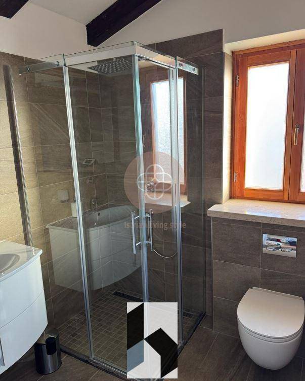 Modernes Badezimmer mit Duschkabine, Wand-WC und Fenster.