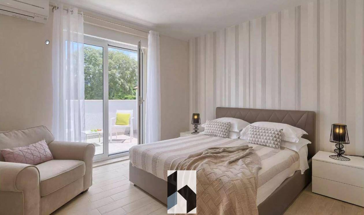 Gemütliches Schlafzimmer mit Doppelbett, gestreifter Tapete und Balkonzugang.