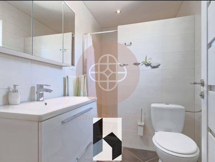 Modernes Badezimmer mit Waschtisch, Spiegelschrank und Duschbereich.