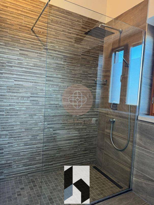 Große begehbare Dusche mit Regenduschkopf und modernen Fliesen.