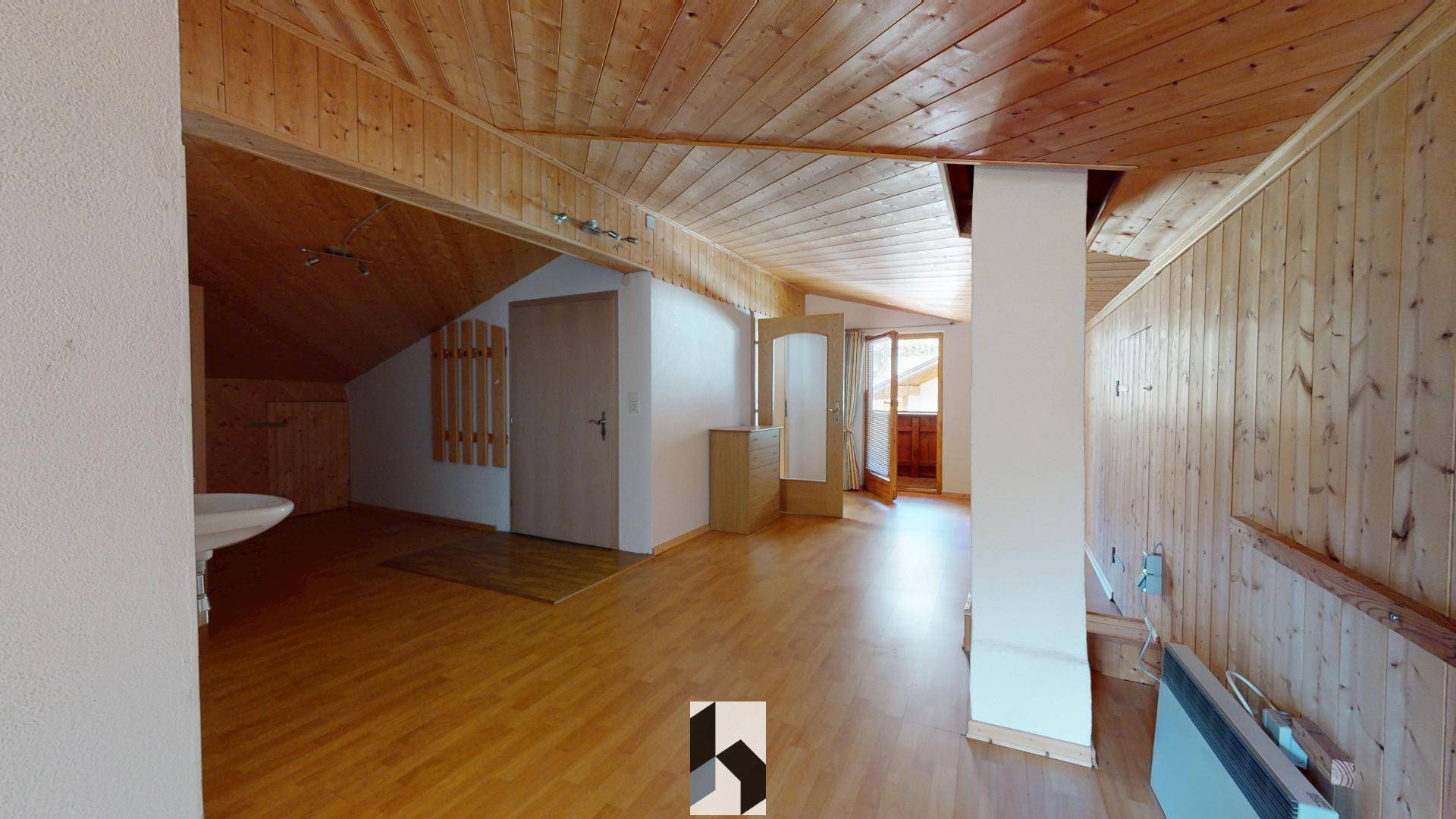 Heller Dachgeschossflur mit Holzverkleidung und schrägen Decken.