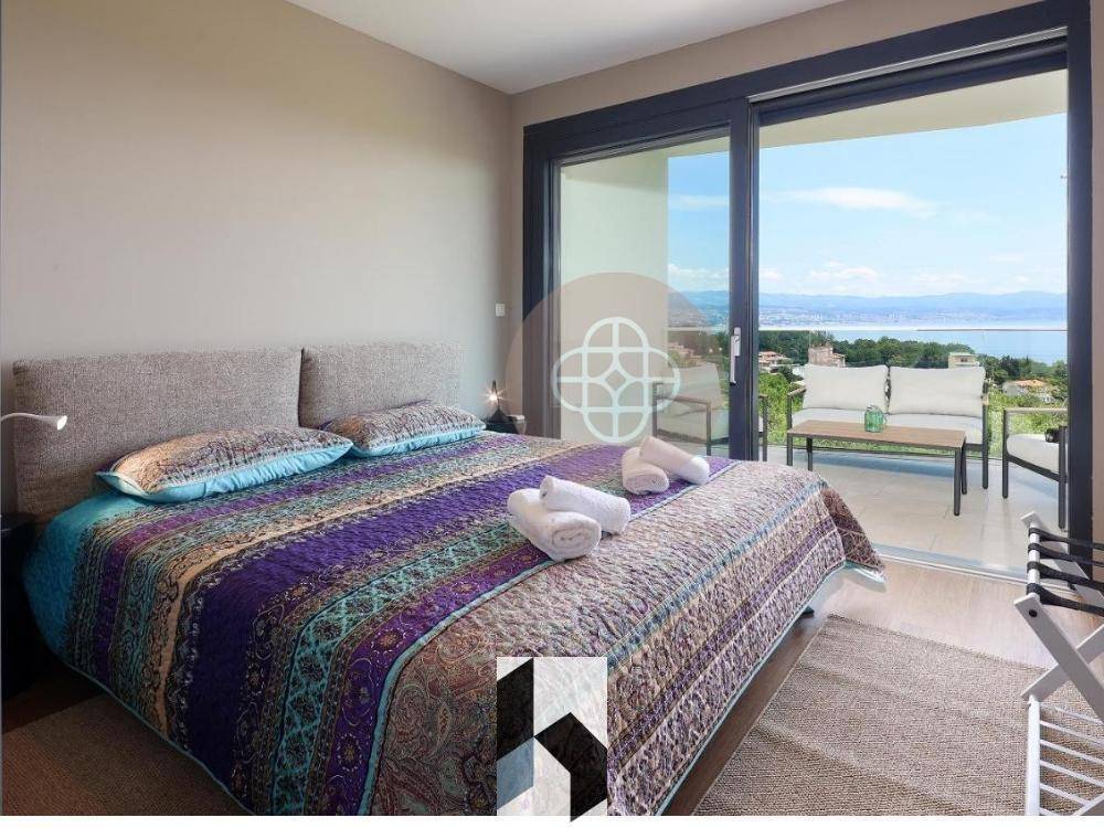 Gemütliches Schlafzimmer mit großem Bett, Balkonzugang und atemberaubendem Meerblick.