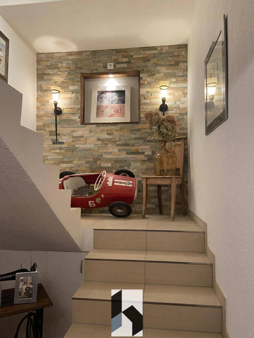Treppenaufgang mit dekorativer Steinwand und indirekter Beleuchtung.