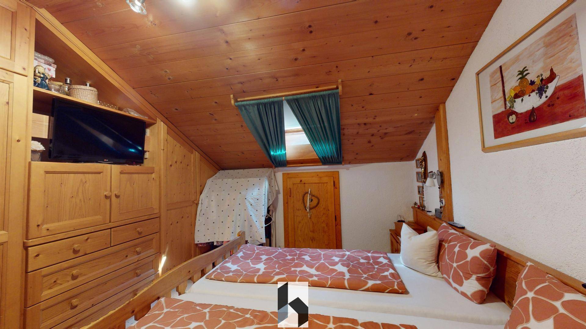 Schlafzimmer im Dachgeschoss mit Holzbett, Einbauschränken und Dachfenster.