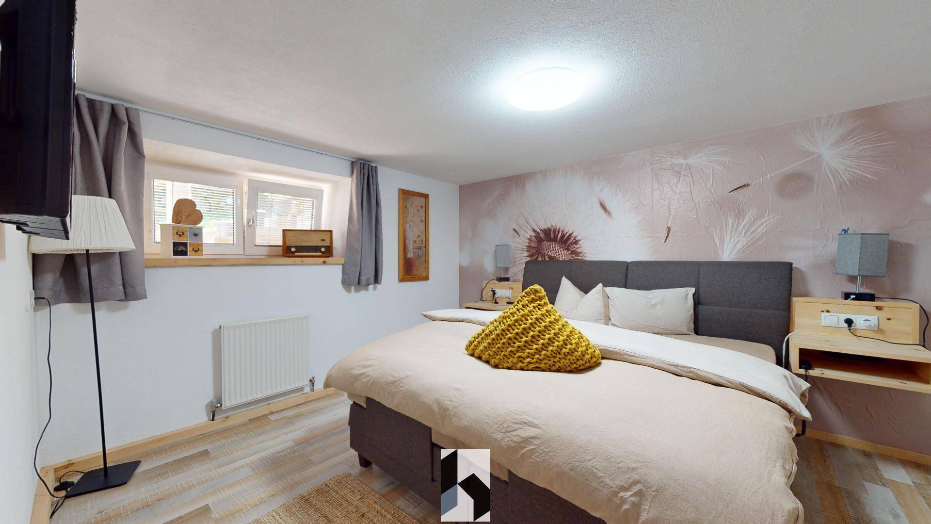 Helles Schlafzimmer mit modernem Wanddesign, Holzboden und großem Bett.