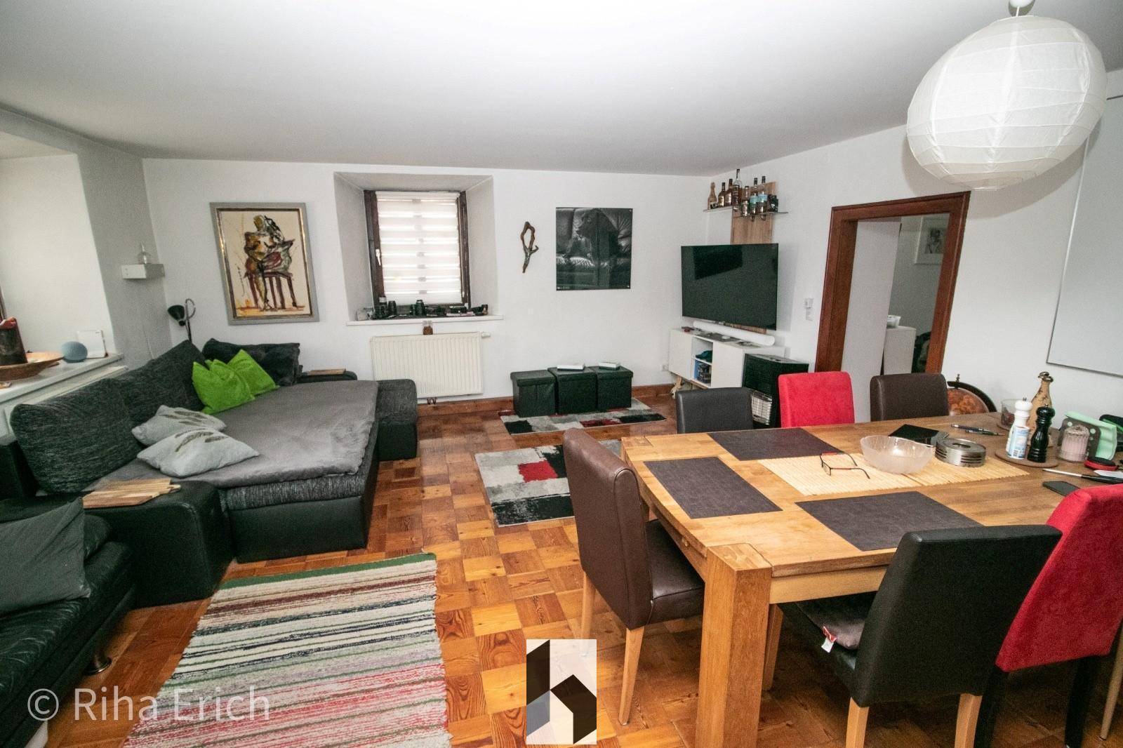 Heller Wohn-Essbereich mit Fernseher, Bar und Holztisch, ideal für gesellige Abende und Unterhaltung.