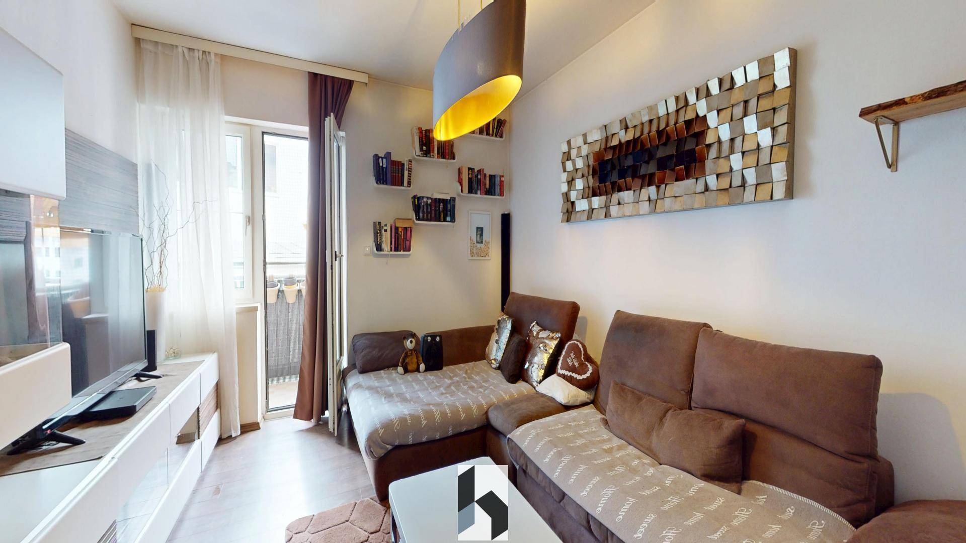 Helles Wohnzimmer mit bequemer Eckcouch, Balkonzugang und moderner Wanddekoration.