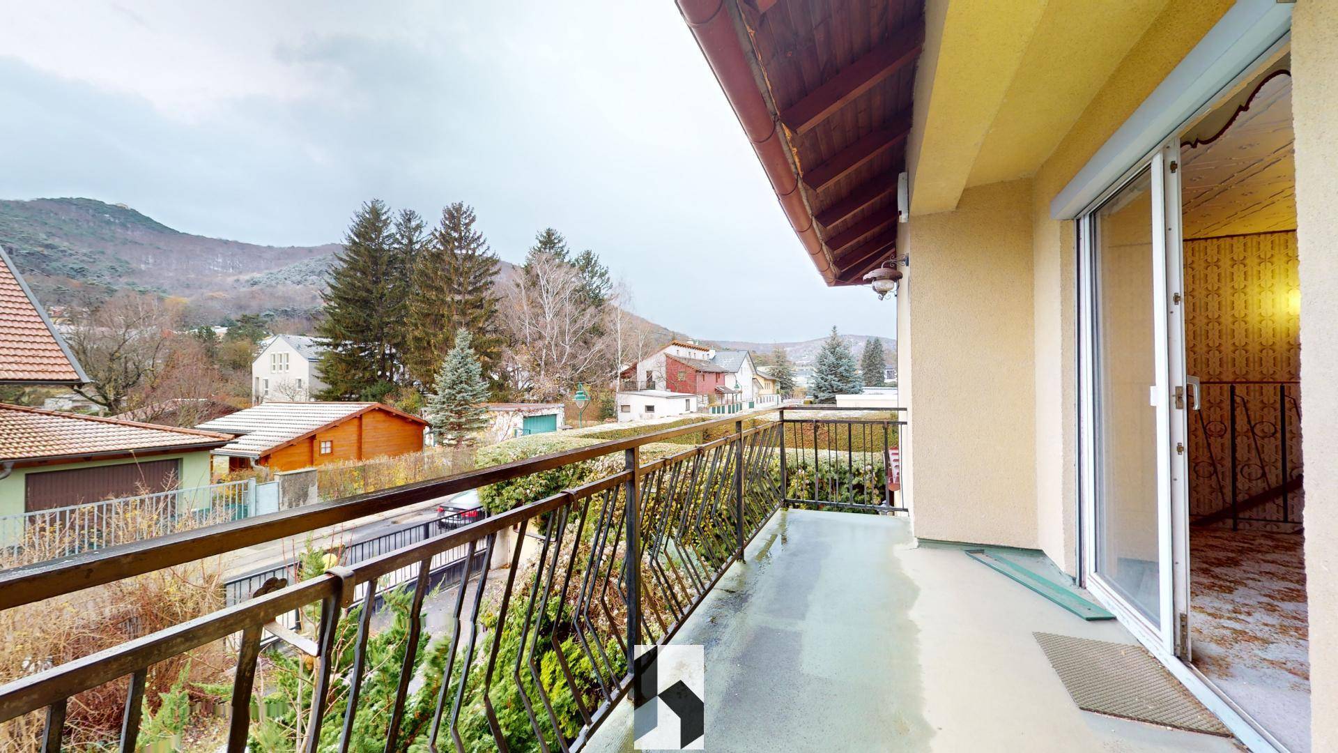 Balkon mit Metallgeländer und weitem Blick auf die umliegende Landschaft und Berge.