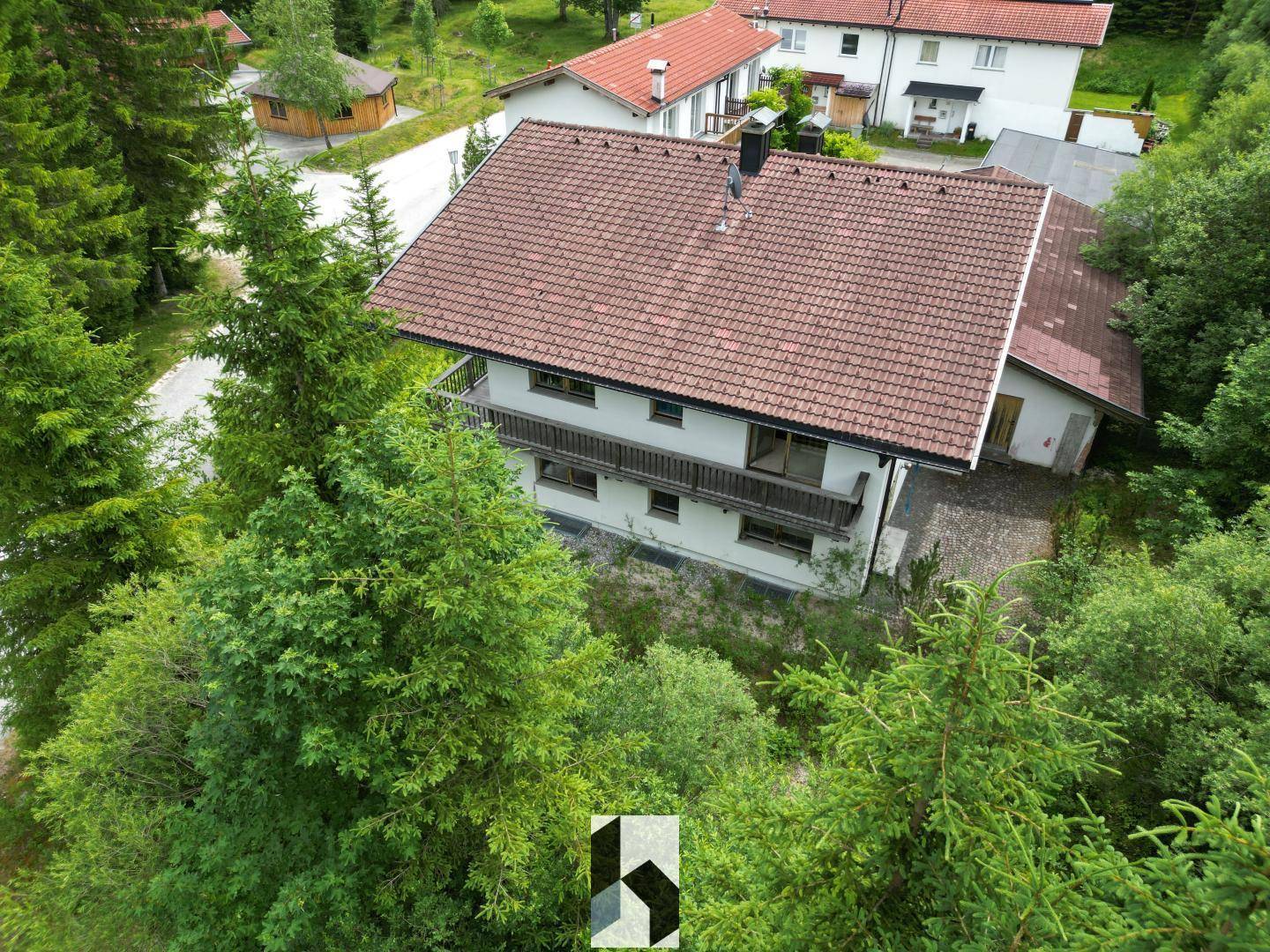 Haus in ländlicher Lage, umgeben von Bäumen und mit Blick auf die Nachbarschaft.