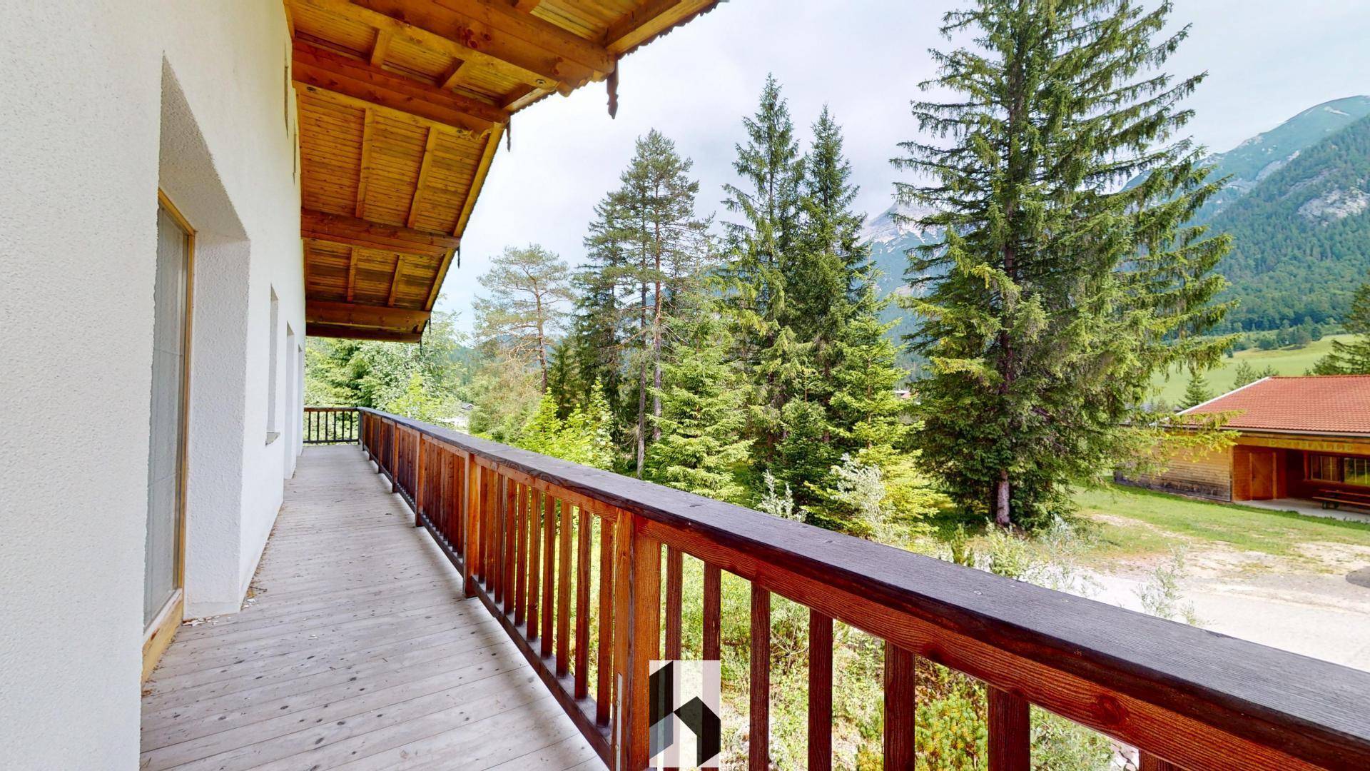 Langer Holzbalkon mit Bergblick, ideal zum Entspannen und Genießen der Natur.