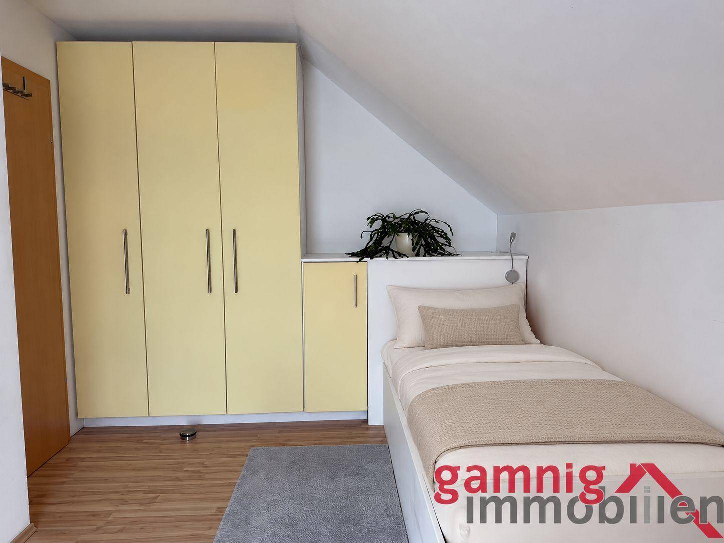 Kinder- oder Gästezimmer im Dachgeschoss mit Schräge, Einzelbett und Kleiderschrank.