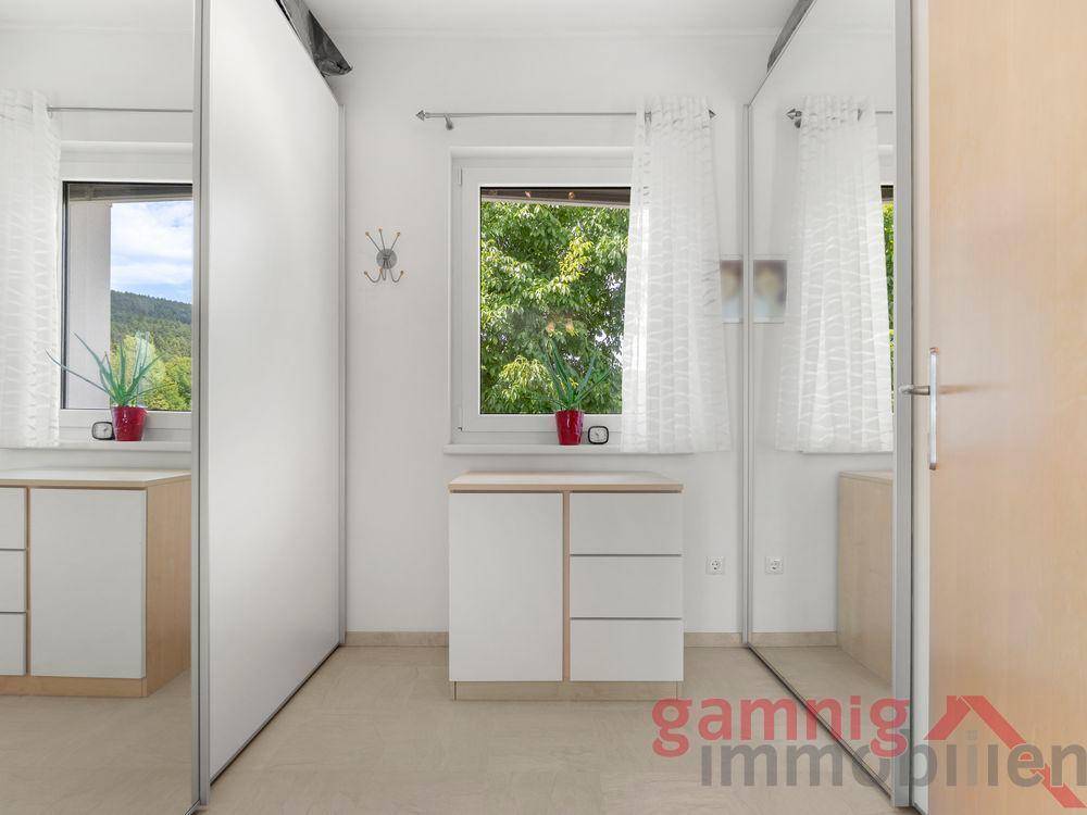 Zimmer mit Spiegelschränken und Fenster mit Blick auf die Umgebung.