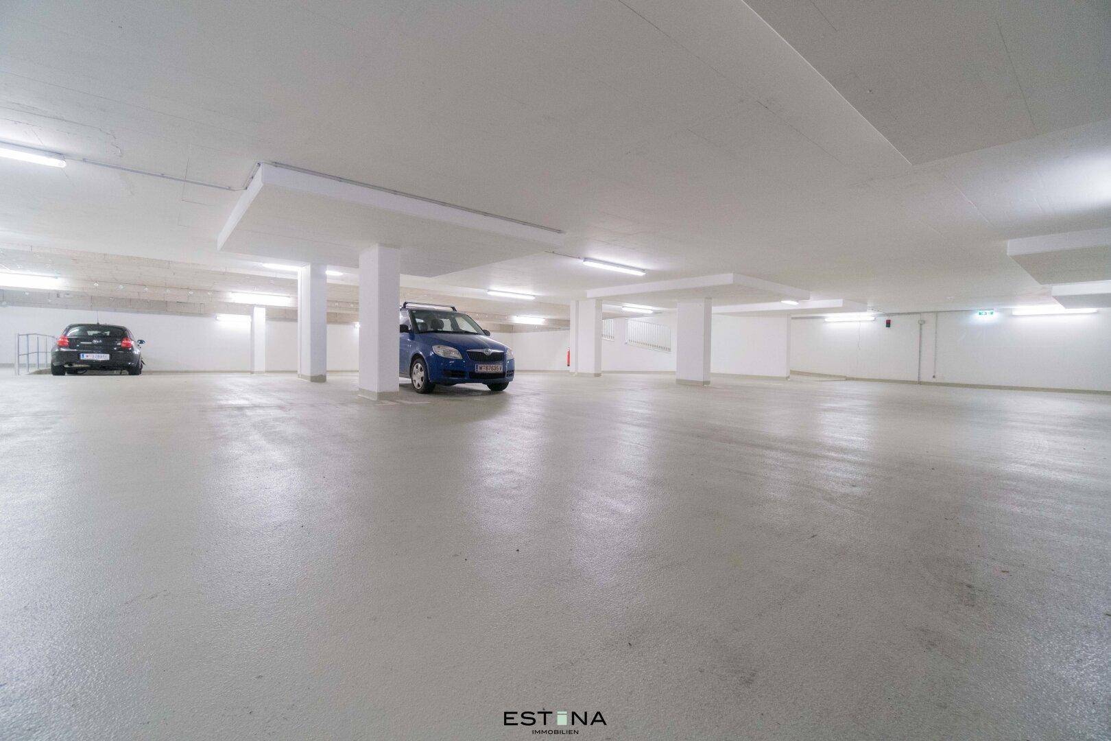Geräumige Tiefgarage mit hellen Wänden und ausreichend Platz für mehrere Fahrzeuge.