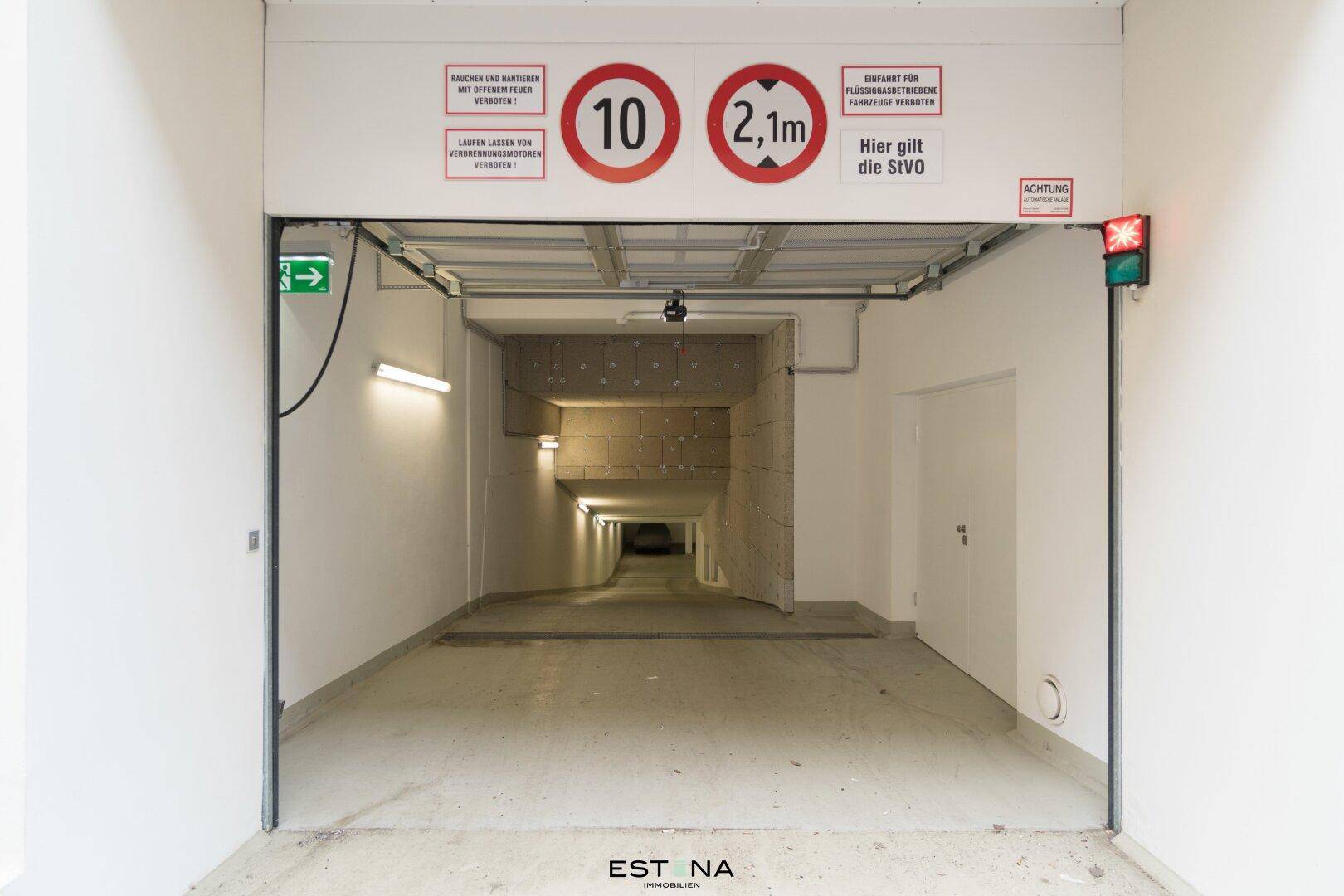 Einfahrt zur Tiefgarage mit klarer Beschilderung für Geschwindigkeit und Höhe.