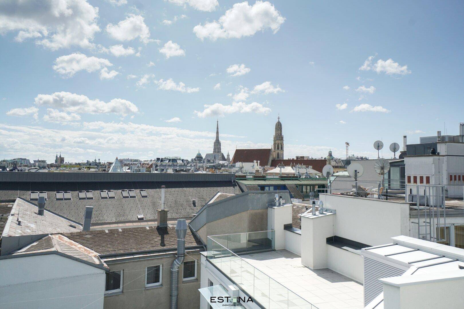 Panoramablick über die Stadt mit historischen Gebäuden und Dächern unter blauem Himmel.