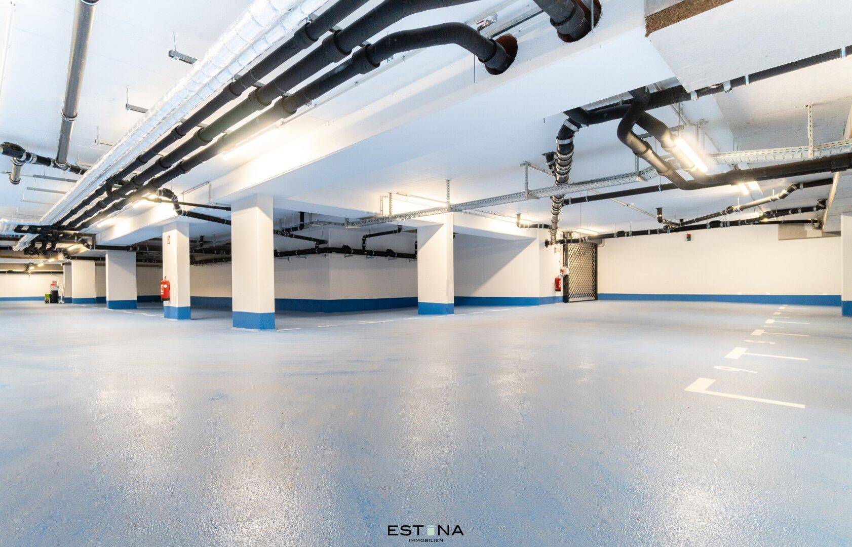 Saubere und helle Tiefgarage mit zahlreichen Parkplätzen und moderner Infrastruktur.