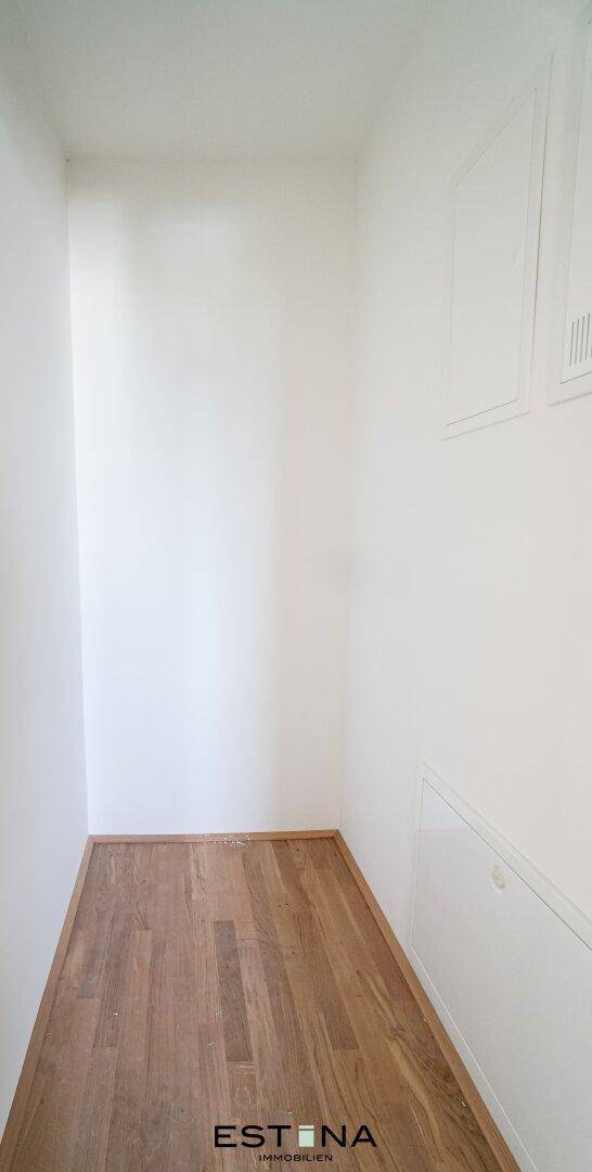 Praktischer Abstellraum mit Holzboden und weißen Wänden, ideal für zusätzlichen Stauraum.