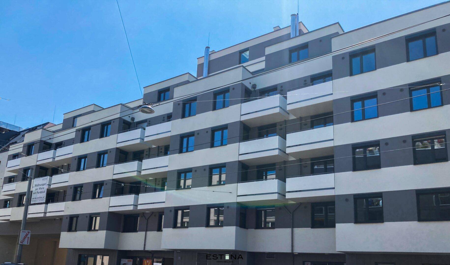 Große moderne Wohnanlage mit vielen Balkonen und einer strukturierten Fassadengestaltung.