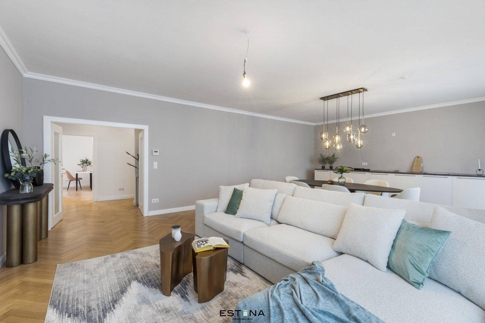 Geräumiger Wohn-Essbereich mit stilvoller Einrichtung und Zugang zu einem weiteren Zimmer.