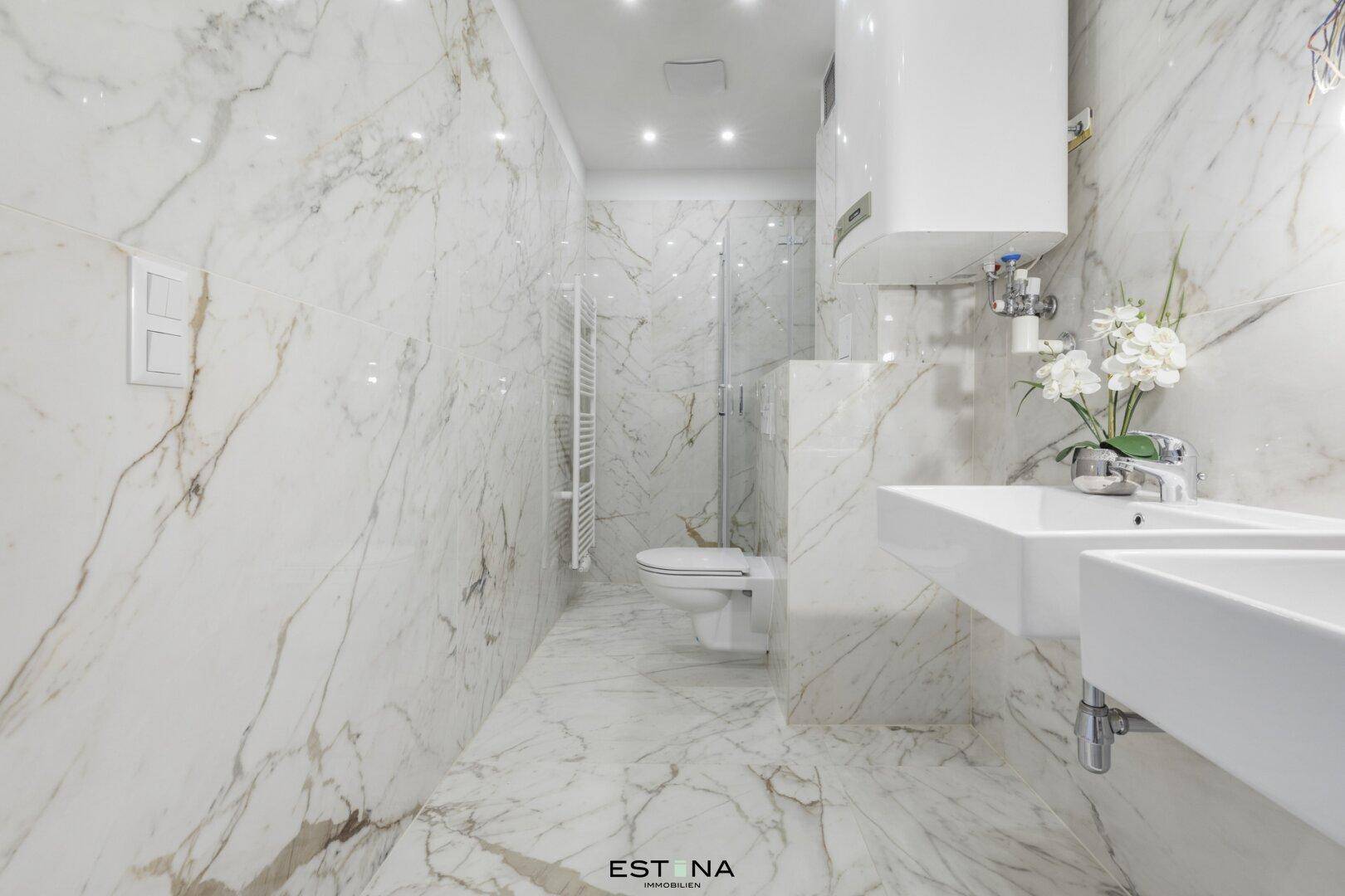 Modernes Badezimmer mit Marmorfliesen, Doppelwaschbecken und begehbarer Dusche.