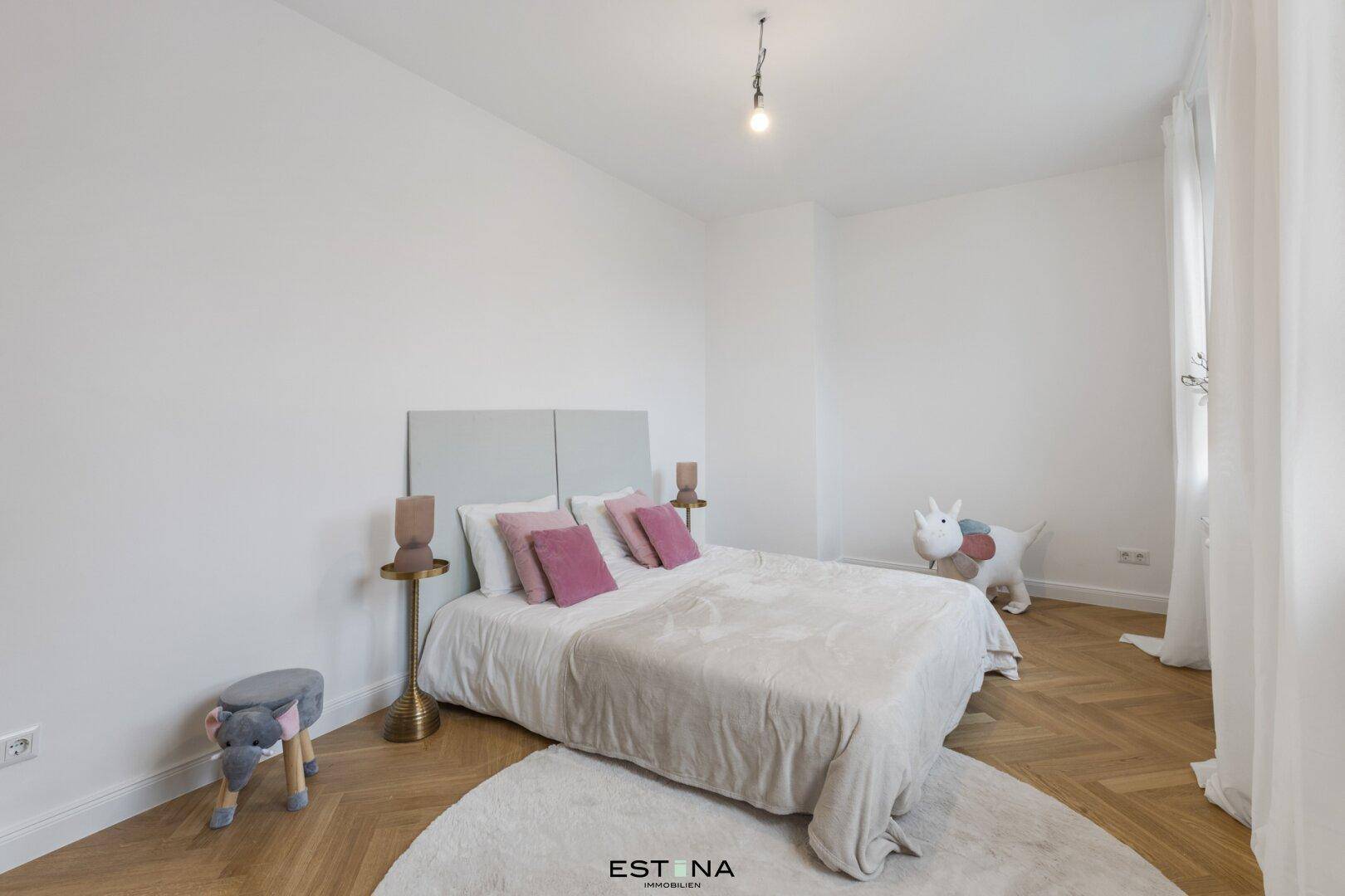 Kinderzimmer mit Einzelbett, verspielter Dekoration und hellem Fischgrätparkettboden.