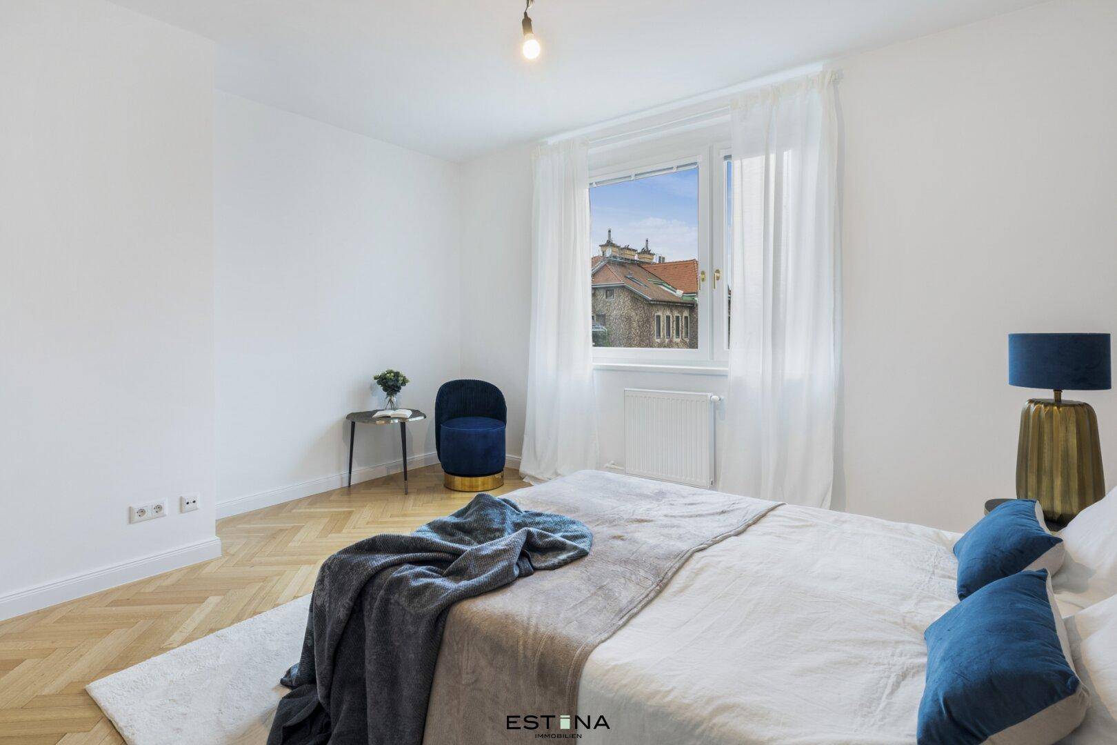 Schlafzimmer mit Blick auf die umliegenden Gebäude und stilvoller Einrichtung.