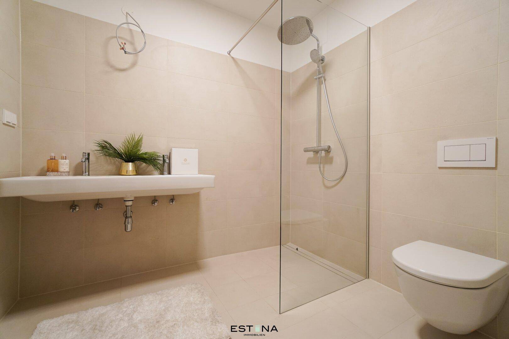 Modernes Badezimmer mit begehbarer Dusche, Wand-WC und beigen Fliesen in zeitlosem Design.