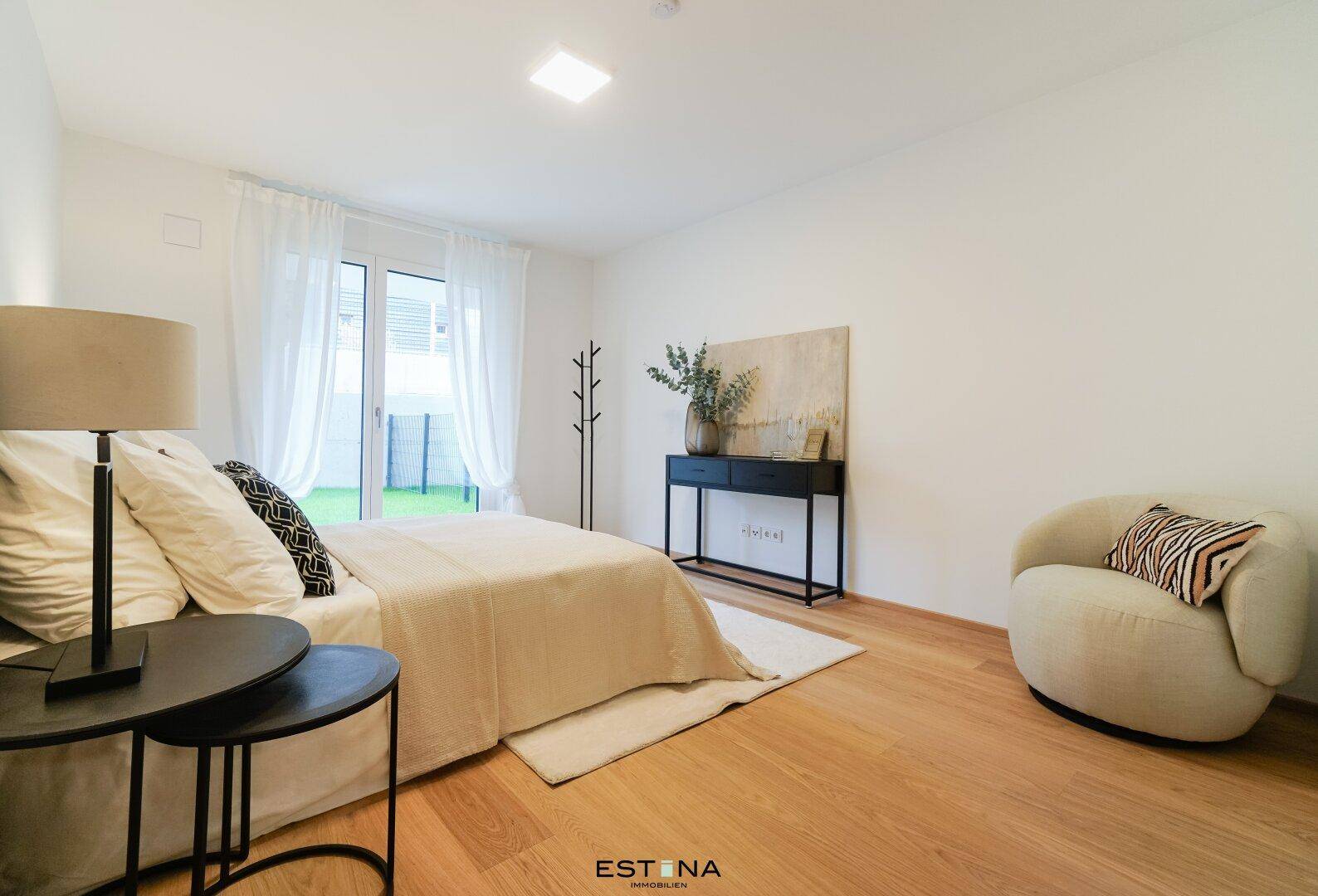 Stilvolles Schlafzimmer mit Holzboden, großem Bett und Zugang zum Außenbereich.